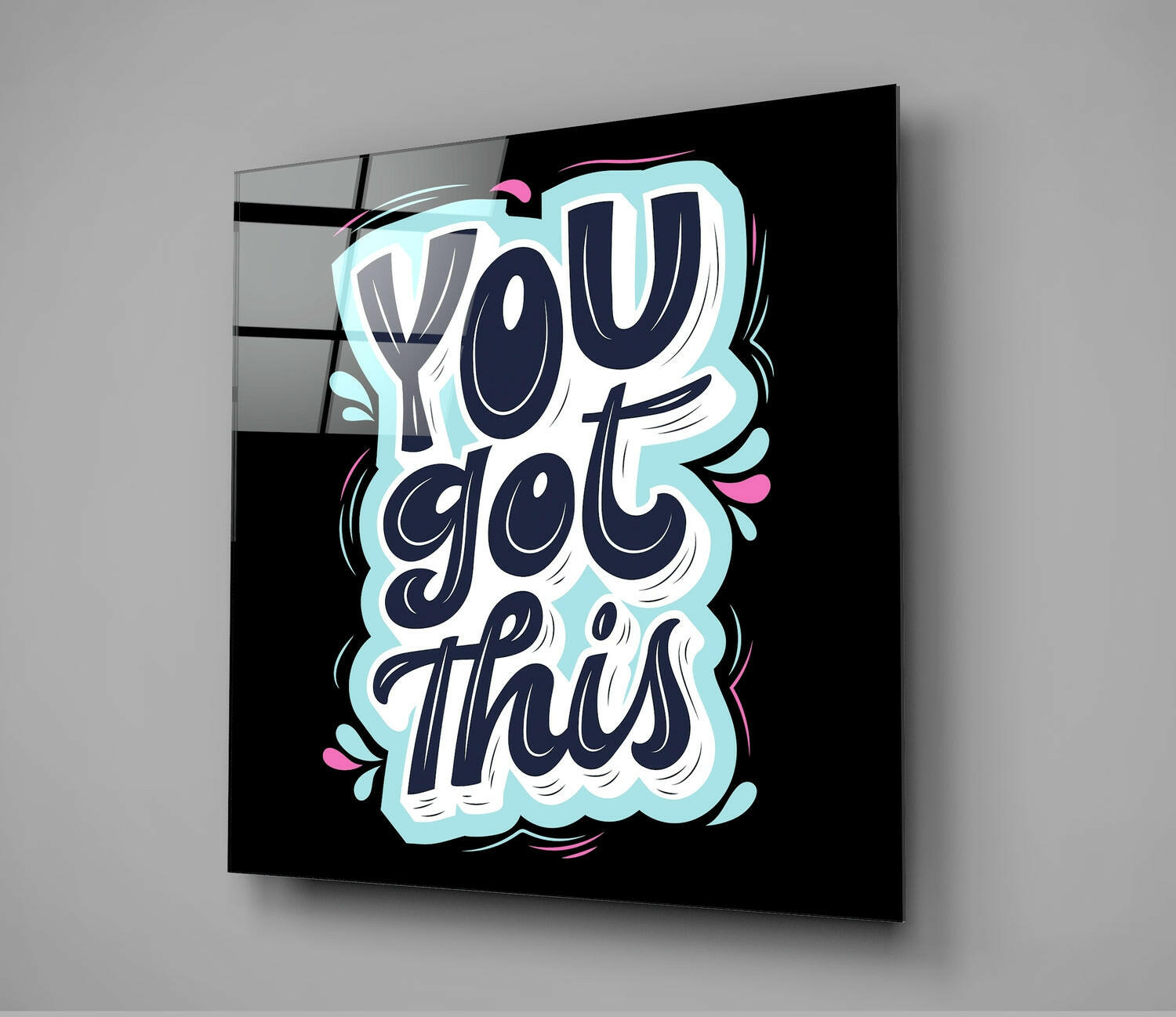Angled view of glass wall art with navy lettering reading "You Got This" on black background, light blue cloud border and pink accents.