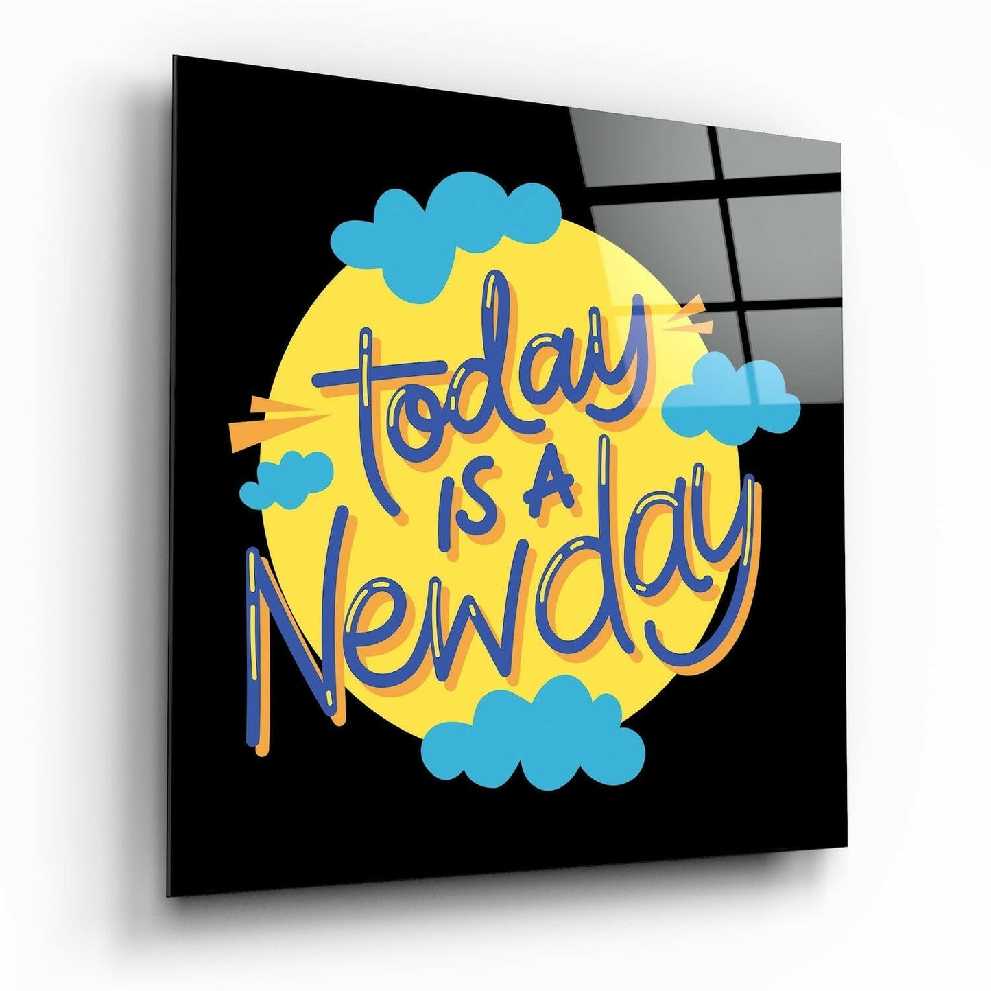 Glass wall art panel displaying "Today is a New Day" text in blue lettering on yellow circle with blue clouds against black background.