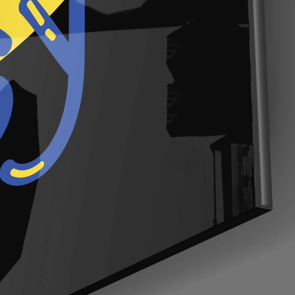 Close-up angled view of blue and yellow "Cake It Easy" logo on dark glass with metallic edge visible.