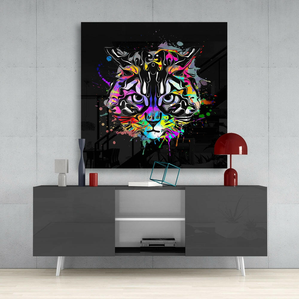 Colorful abstract tiger head art glass panel displayed on gray media console with red lamp and white accessories against concrete wall.