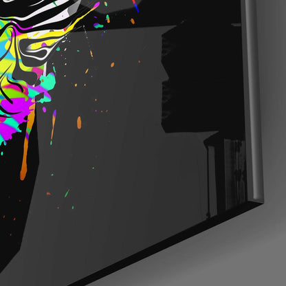 Colorful neon abstract cat design on black glass panel displayed at an angle against gray wall.