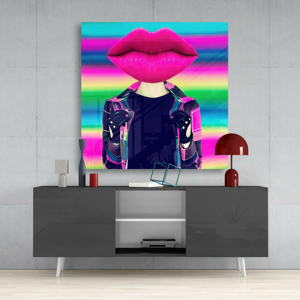 Colorful glass wall art featuring oversized magenta lips and figure in neon jacket displayed above gray media console in modern interior setting.