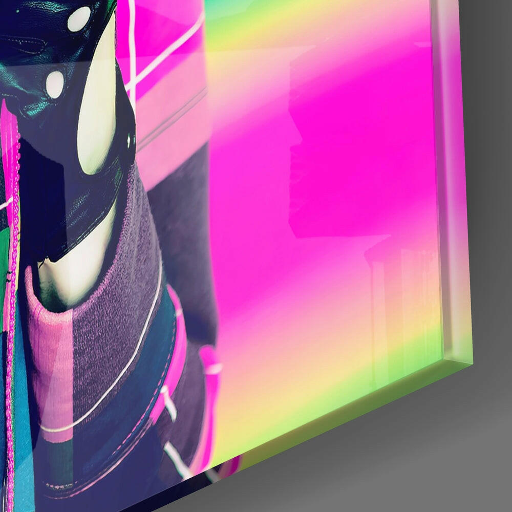 Close-up angled view of glass wall art featuring a stylized face with white lips against vibrant pink, yellow, and green gradient background.