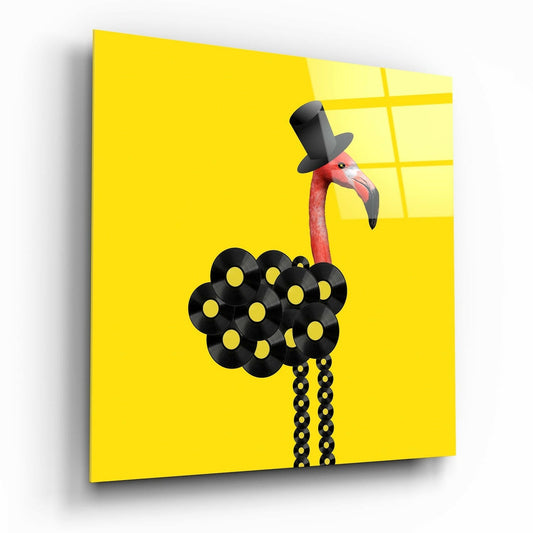 Yellow glass wall art panel displaying a stylized flamingo wearing a black top hat, with vinyl records forming its body and chain legs.