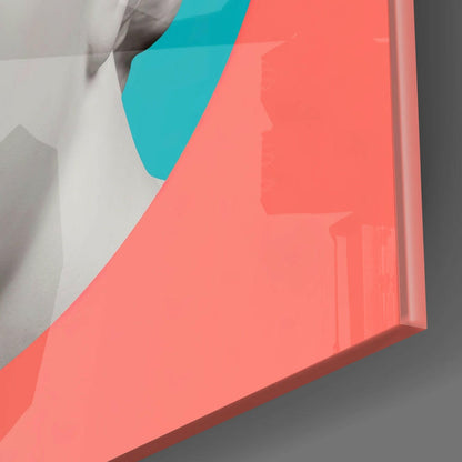 Angled side view of coral and turquoise glass wall art sculpture with visible edge and shadow on gray surface.