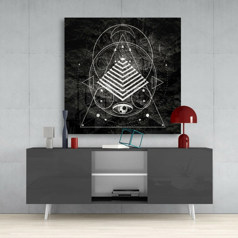 Black and white geometric sacred geometry canvas art displayed above a gray media console with red accents in a modern interior setting.
