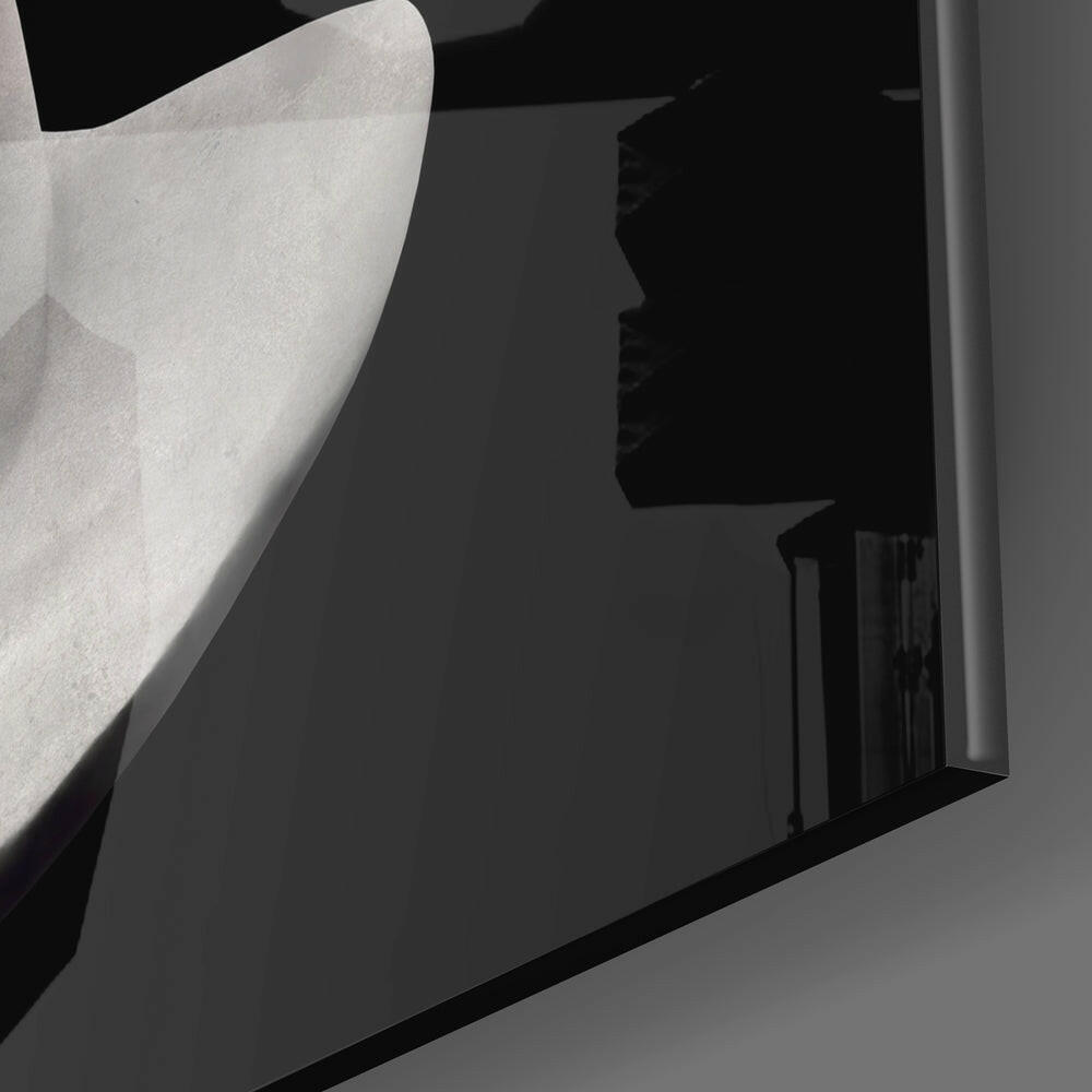 Close-up detail of translucent frosted glass sculpture head with curved profile against dark background and metal frame edge.