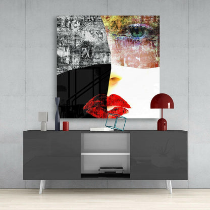 Modern living room setup displaying abstract glass wall art with distressed textures, red lips, and colorful elements above a dark console table.