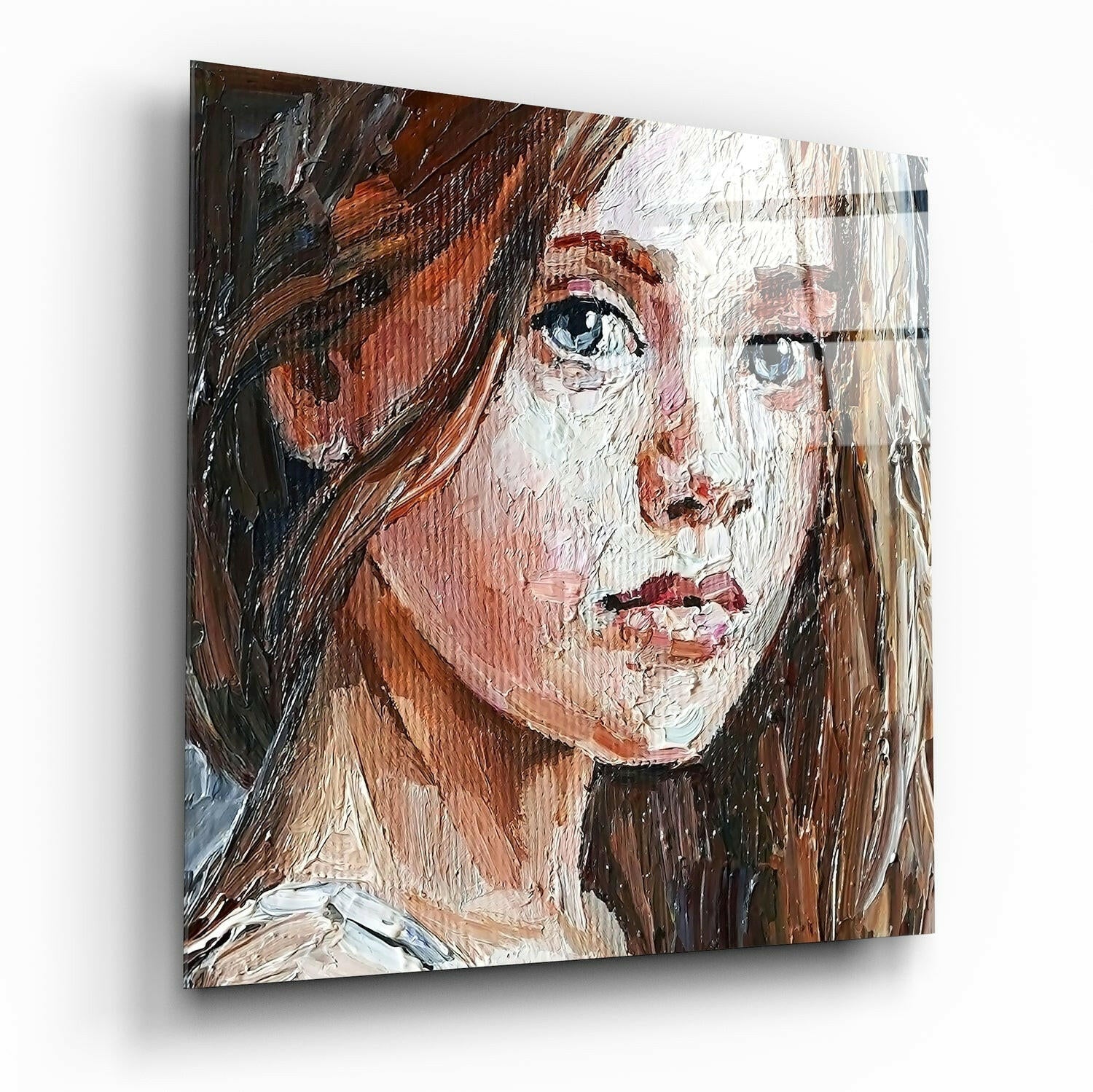 Angled view of glass wall art depicting a portrait of a woman with long brown hair and blue eyes, painted in expressive brushstrokes with warm flesh tones and dark accents.