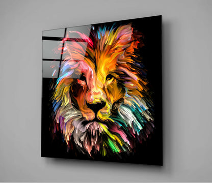 Colorful lion head portrait on black glass panel displayed at an angle against gray wall, showing vibrant rainbow paint strokes.