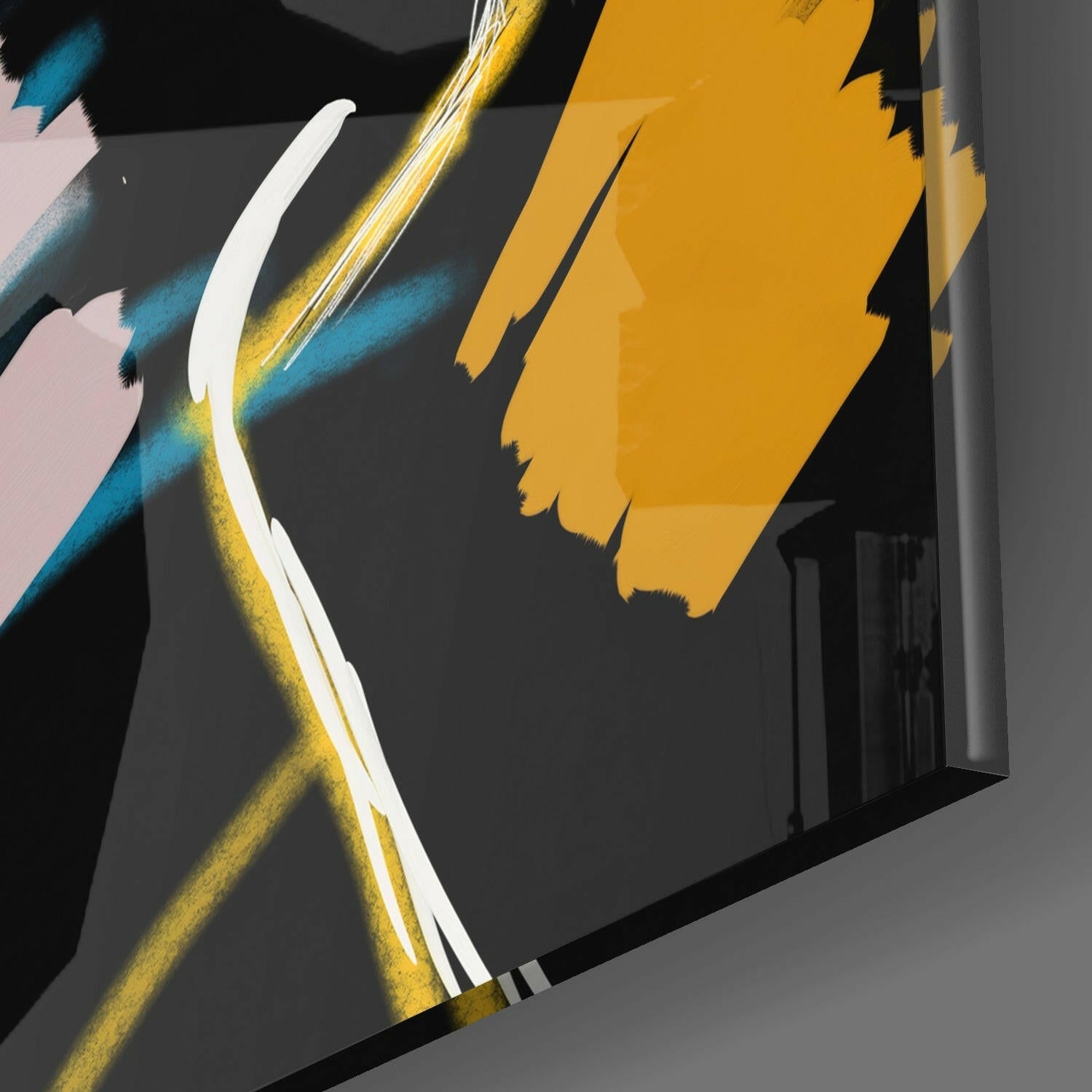 Close-up angle of glass wall art featuring bold yellow, blue, and white brushstroke designs against dark background.