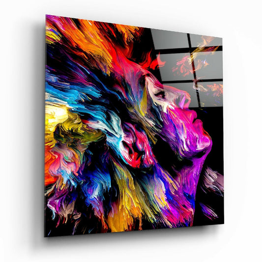 Angled view of glass wall art featuring an abstract lion's head in vibrant swirling colors of pink, purple, blue, yellow, and orange against black background.