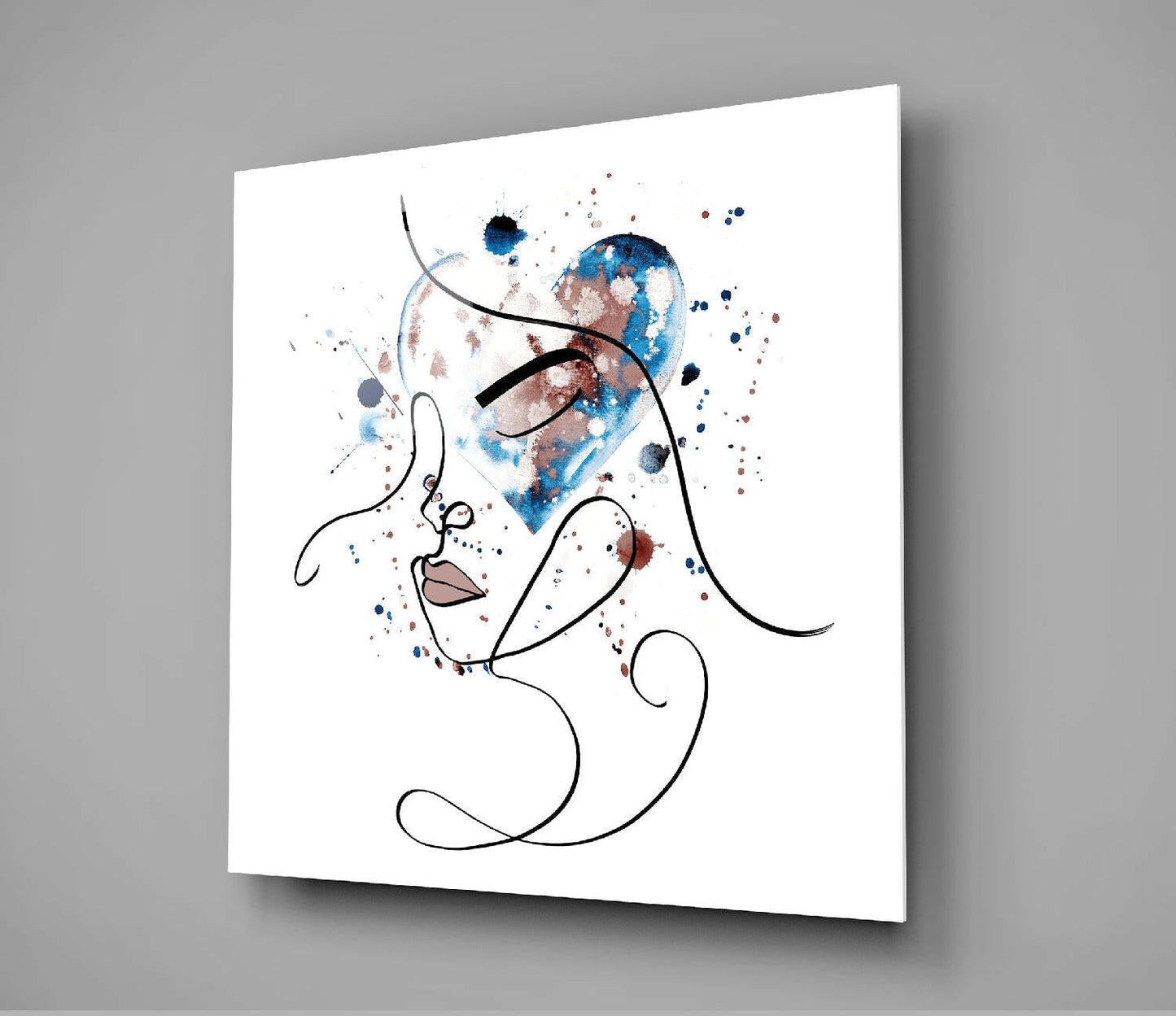 Modern line art glass wall art displaying an abstract face profile with watercolor blue and brown splashes against white background, mounted at angle.