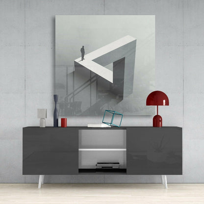 Dead End Glass Wall Art mounted above a dark gray media console, displaying a surreal 3D illustration of a figure on an impossible geometric structure in grayscale tones.
