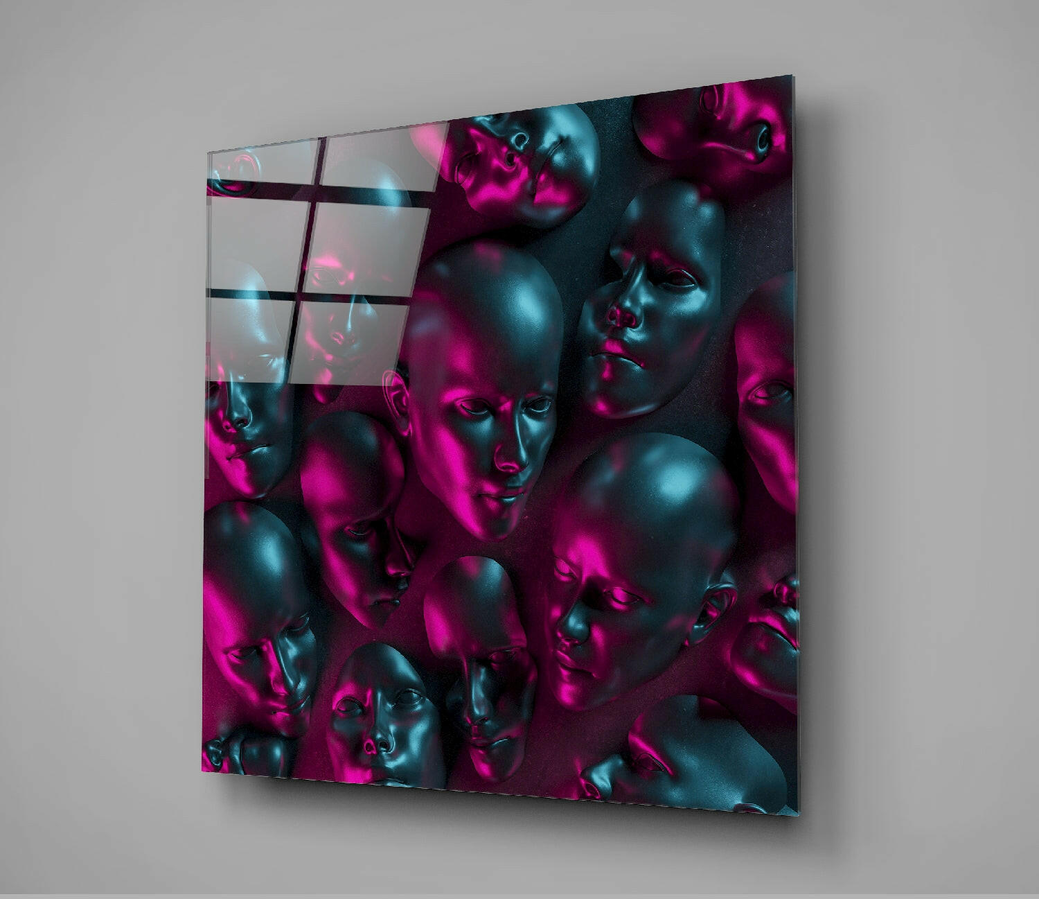 Square glass wall art panel displaying metallic sculptural faces illuminated in magenta and cyan lighting with dark grid overlay, angled perspective view.