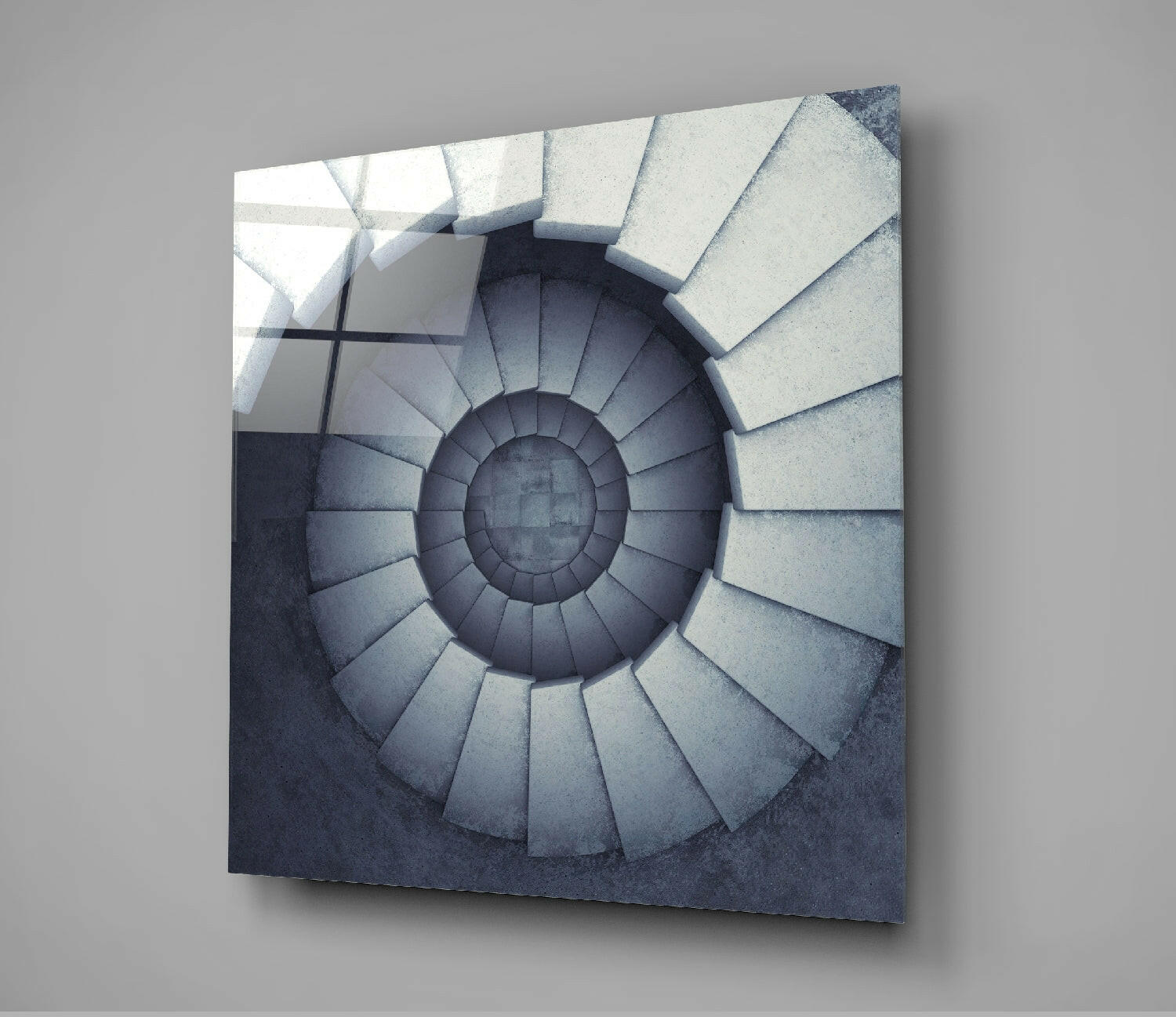 Square glass panel displaying a spiral staircase descending into shadow, rendered in grayscale tones, mounted on gray wall.
