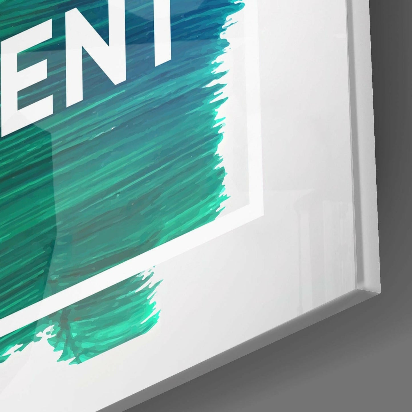 Close-up angled view of white-framed glass wall art with turquoise brushstroke design and partial "ENJ" text visible.