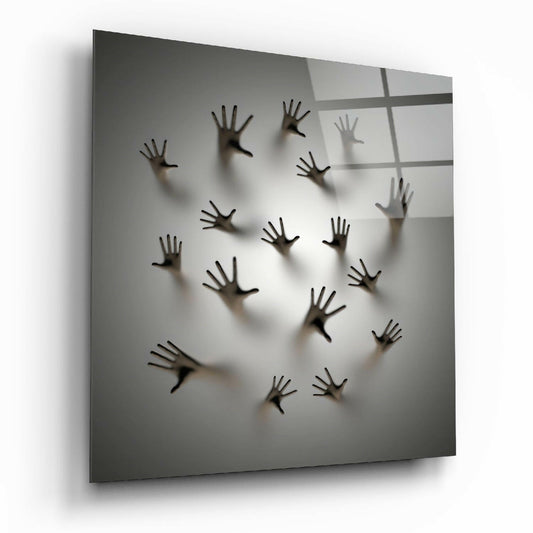 Multiple dark hands pressed against translucent frosted glass panel with window grid shadows cast across surface.