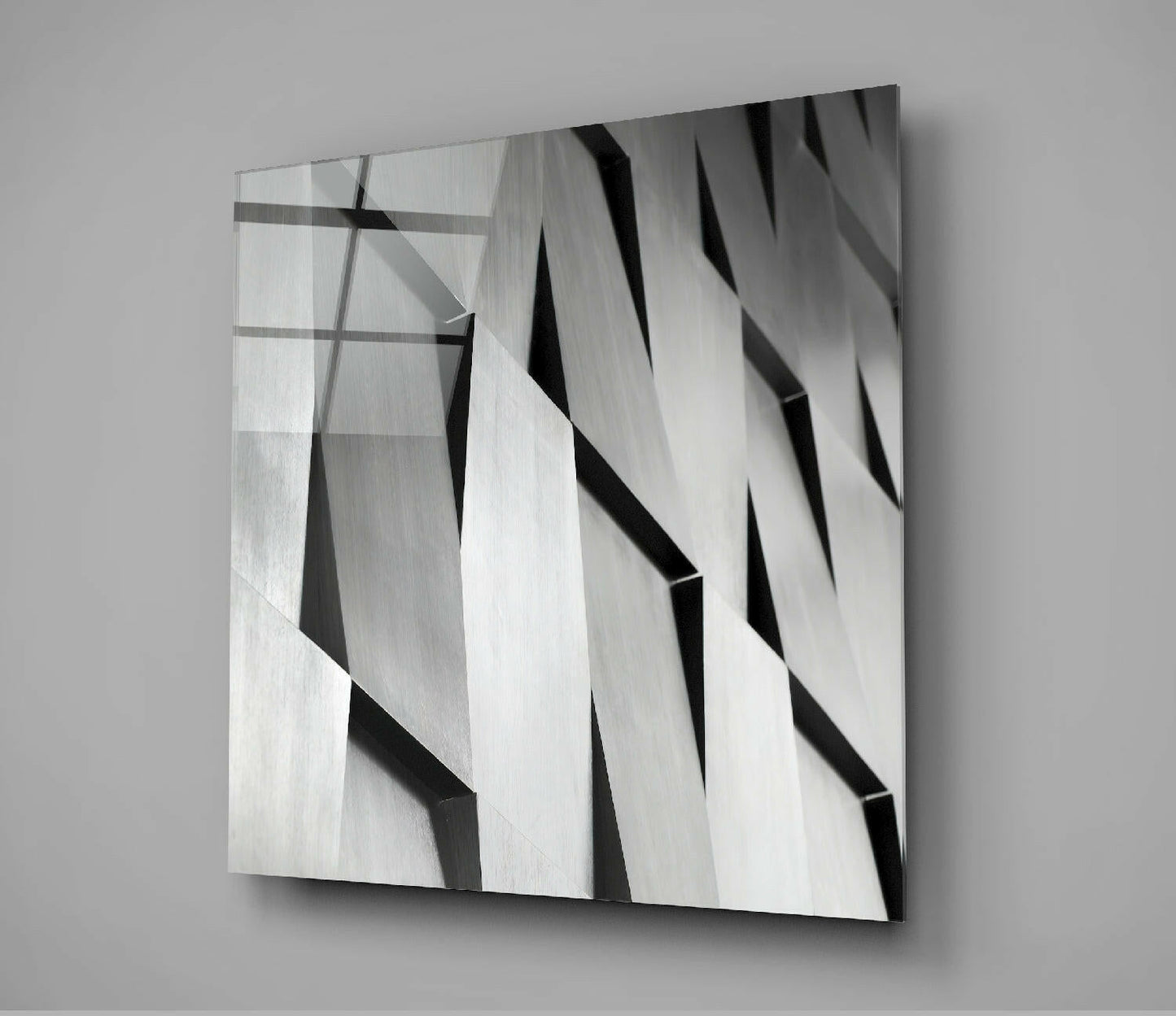 Modern abstract glass wall art with diagonal black and white striped pattern and layered dimensional effect, mounted on gray wall.