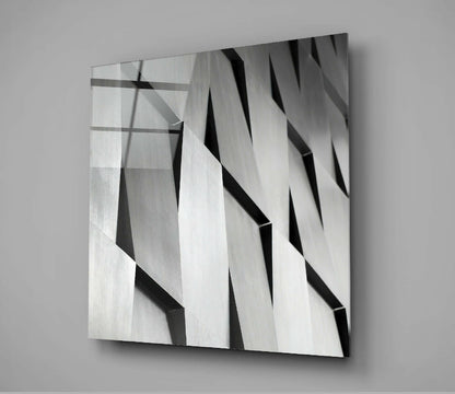 Modern abstract glass wall art with diagonal black and white striped pattern and layered dimensional effect, mounted on gray wall.