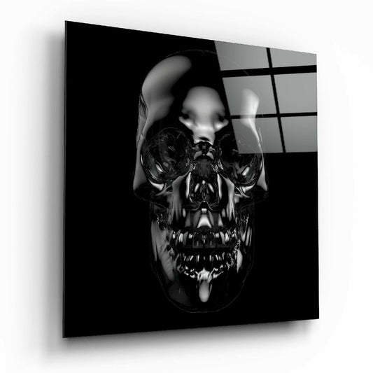 Angled front view of a glossy black chrome skull glass wall art panel with reflective surface and grid-patterned window backdrop.