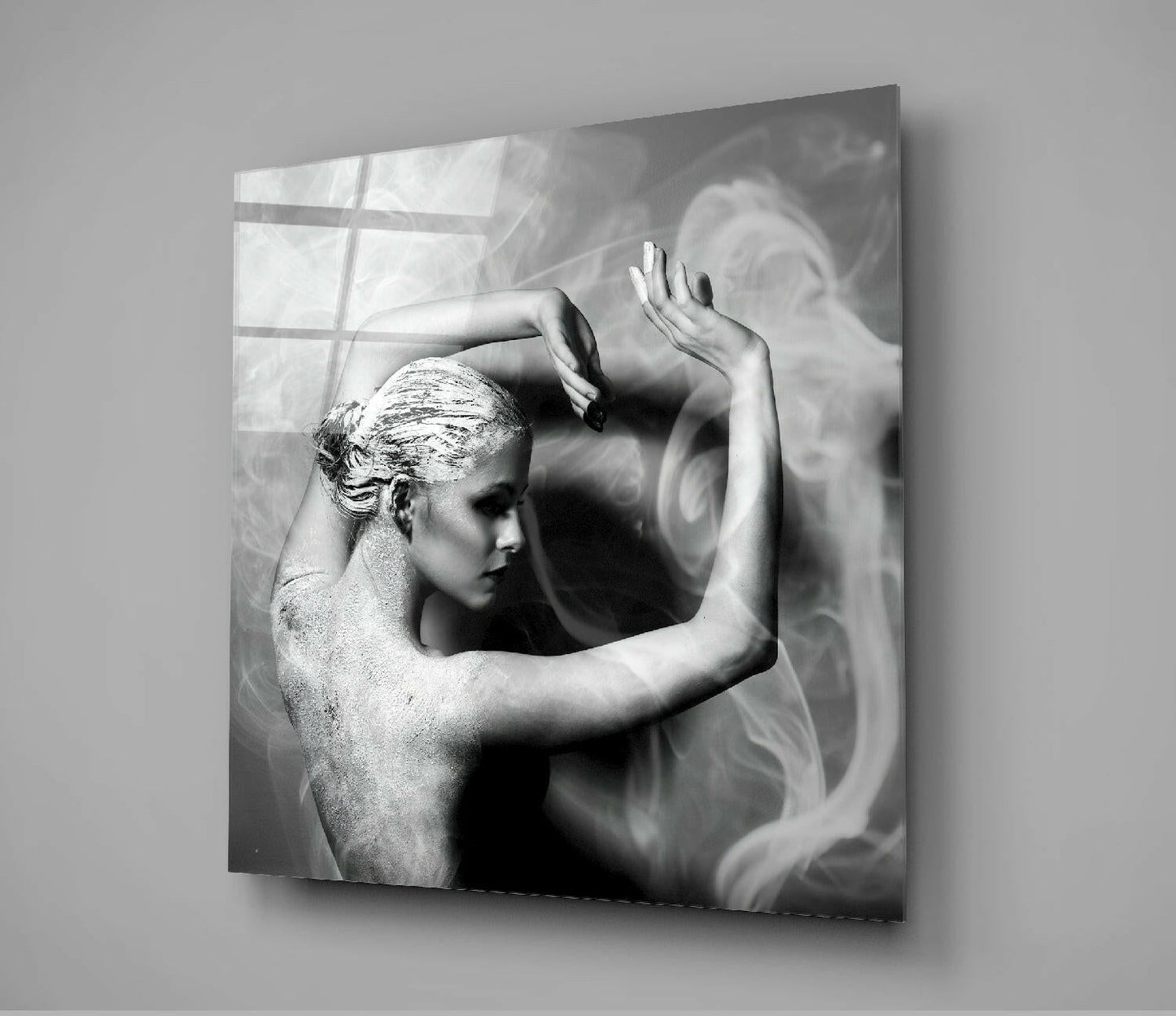 Black and white glass wall art showing a shirtless figure in profile with raised arms against smoky, swirling background patterns.