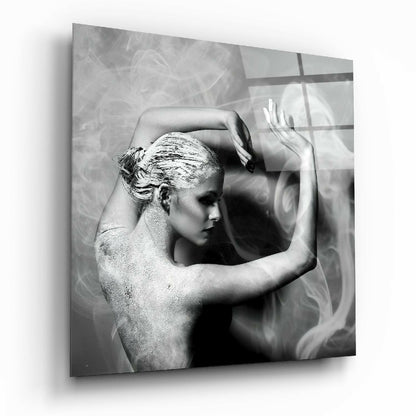 Black and white glass wall art depicting a shirtless figure in profile with gold leaf on hair, hands raised, against textured background with window shadows.