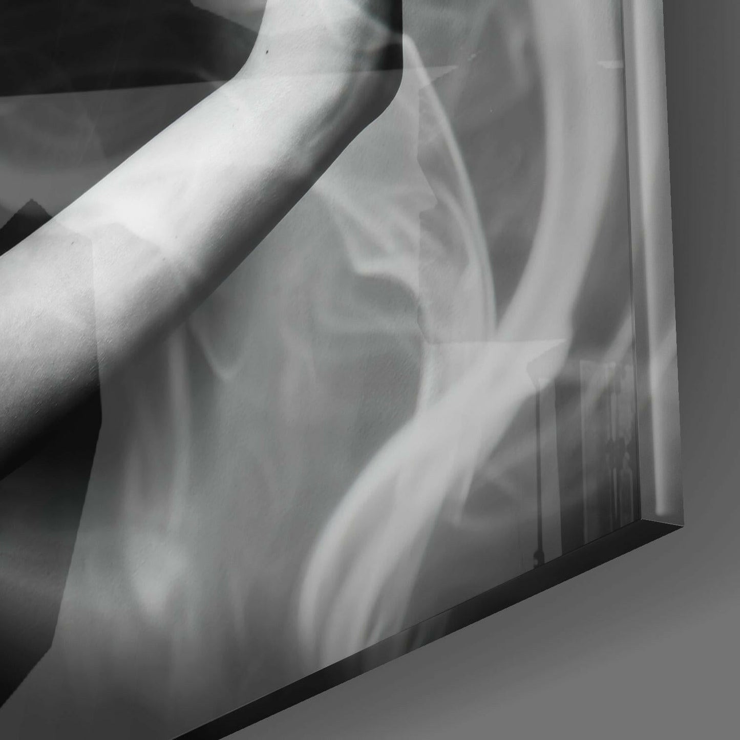 Close-up detail of translucent glass wall art showing swirling smoke-like patterns in monochromatic gray and white tones.