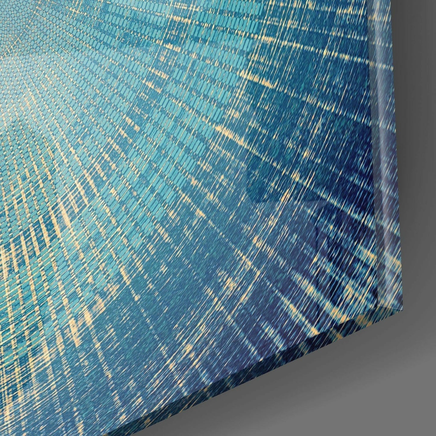 Close-up angled view of blue and gold textured glass surface with linear striped pattern and curved edge detail.