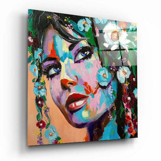 Angled view of a colorful pop art portrait on glass showing a woman's face with vibrant purple, blue, and pink tones surrounded by painted flowers.