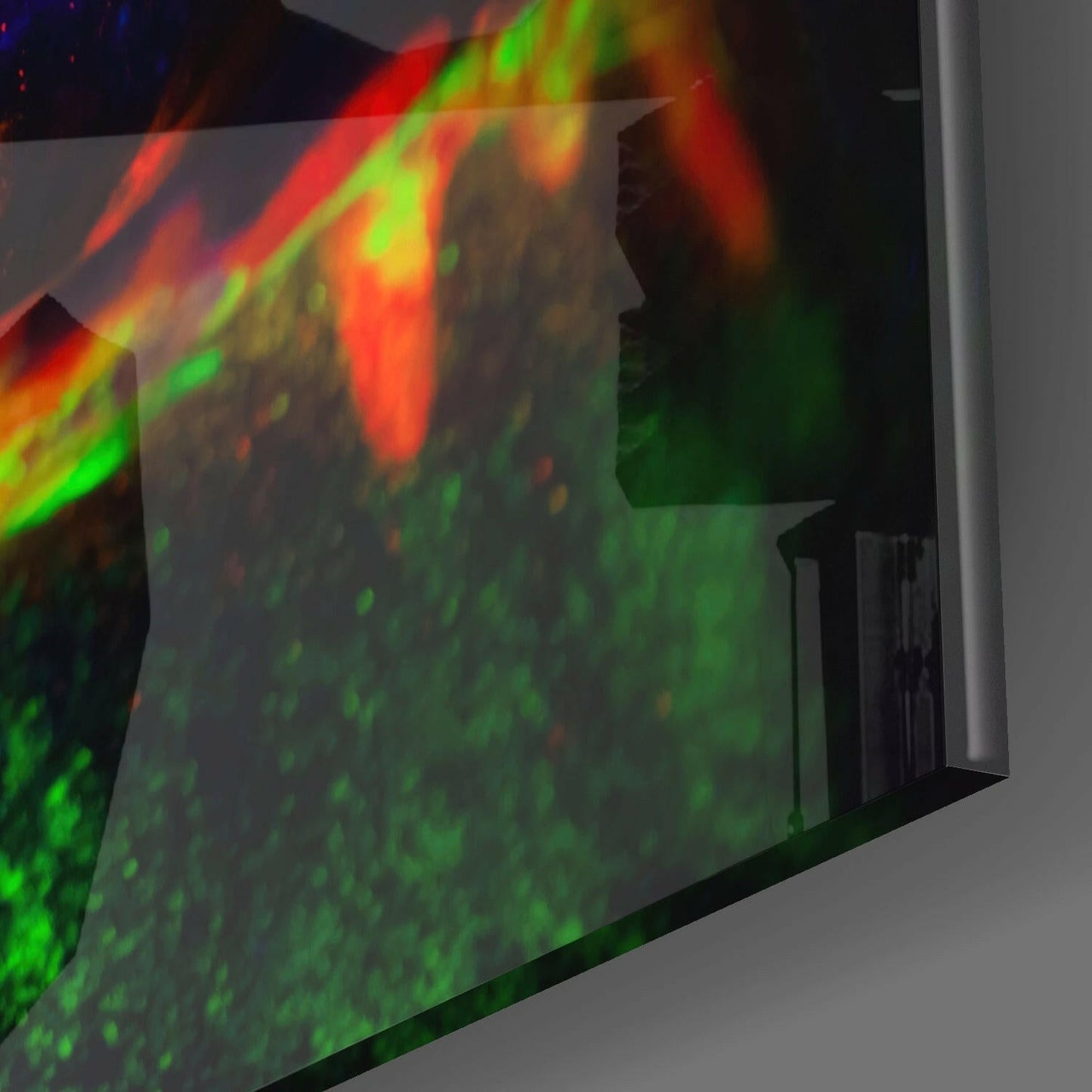 Neon color glass wall art displaying vibrant red, green, and yellow streaks mounted on white wall at angled perspective.