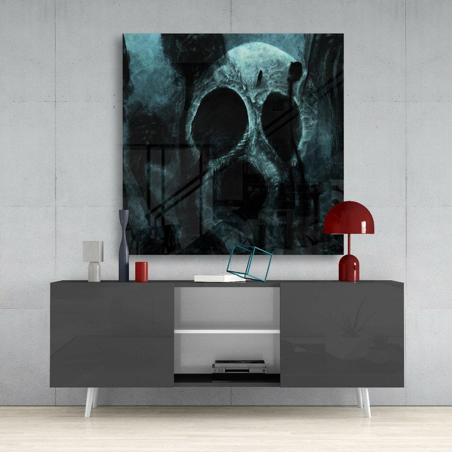 Dark teal skull artwork displayed above gray media console with red lamp and decorative accessories in modern interior setting.