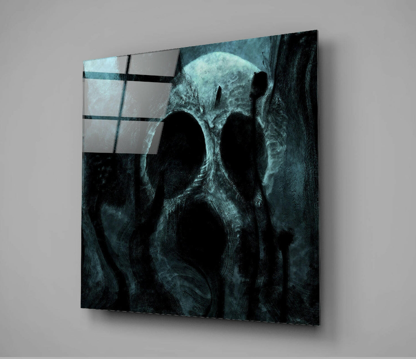 Angled view of dark teal glass wall art featuring a weathered skull with glowing eyes and geometric grid pattern overlay in upper left corner.