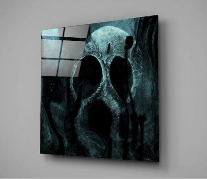 Angled view of dark teal glass wall art featuring a weathered skull with glowing eyes and geometric grid pattern overlay in upper left corner.
