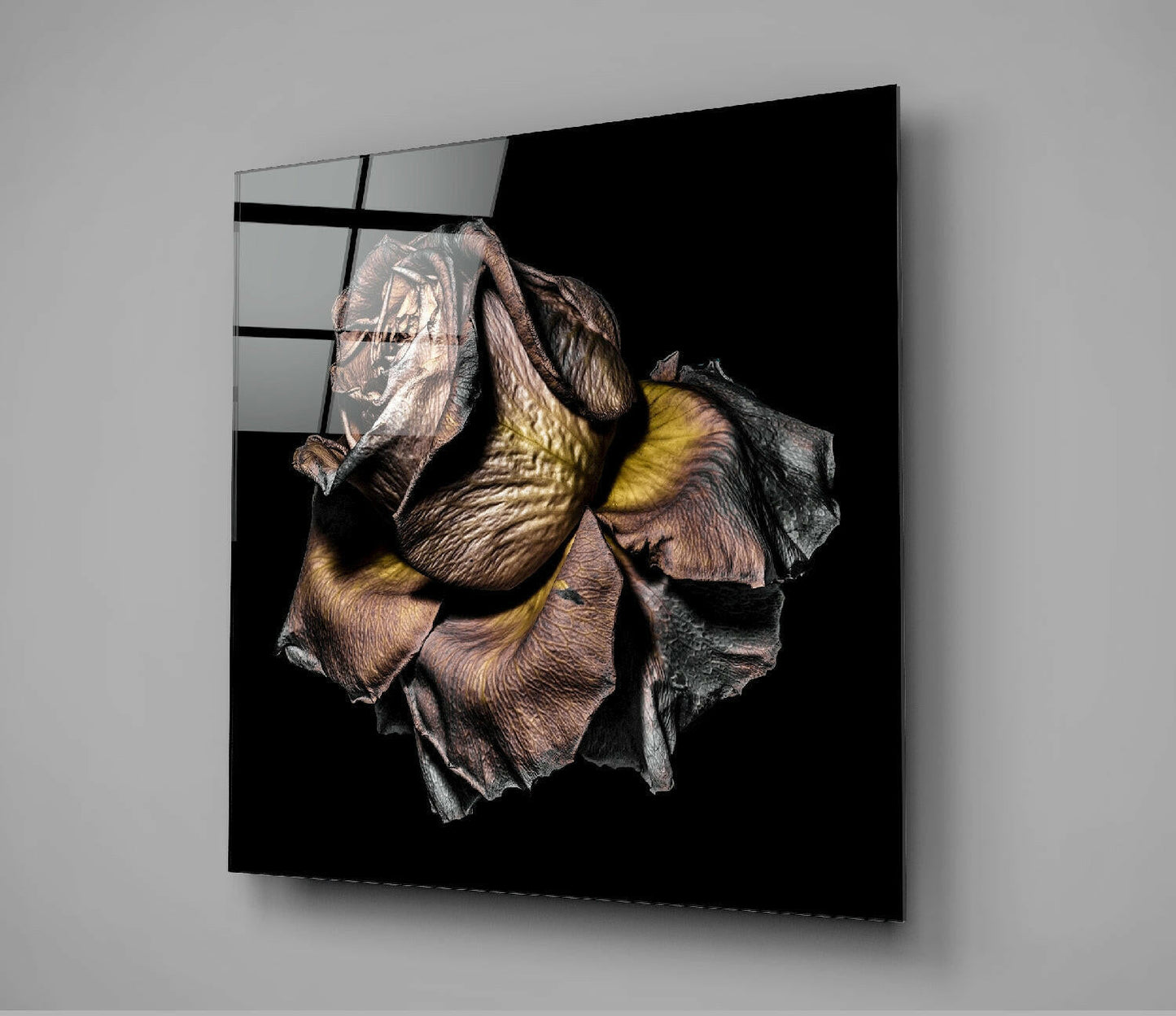 Black glass wall panel displaying a detailed dried rose specimen with brown petals and yellow stamens against dark background.