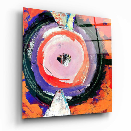 Square glass wall art displayed at an angle showing concentric circles in pink, red, purple, and white against a vibrant orange and multicolored background.