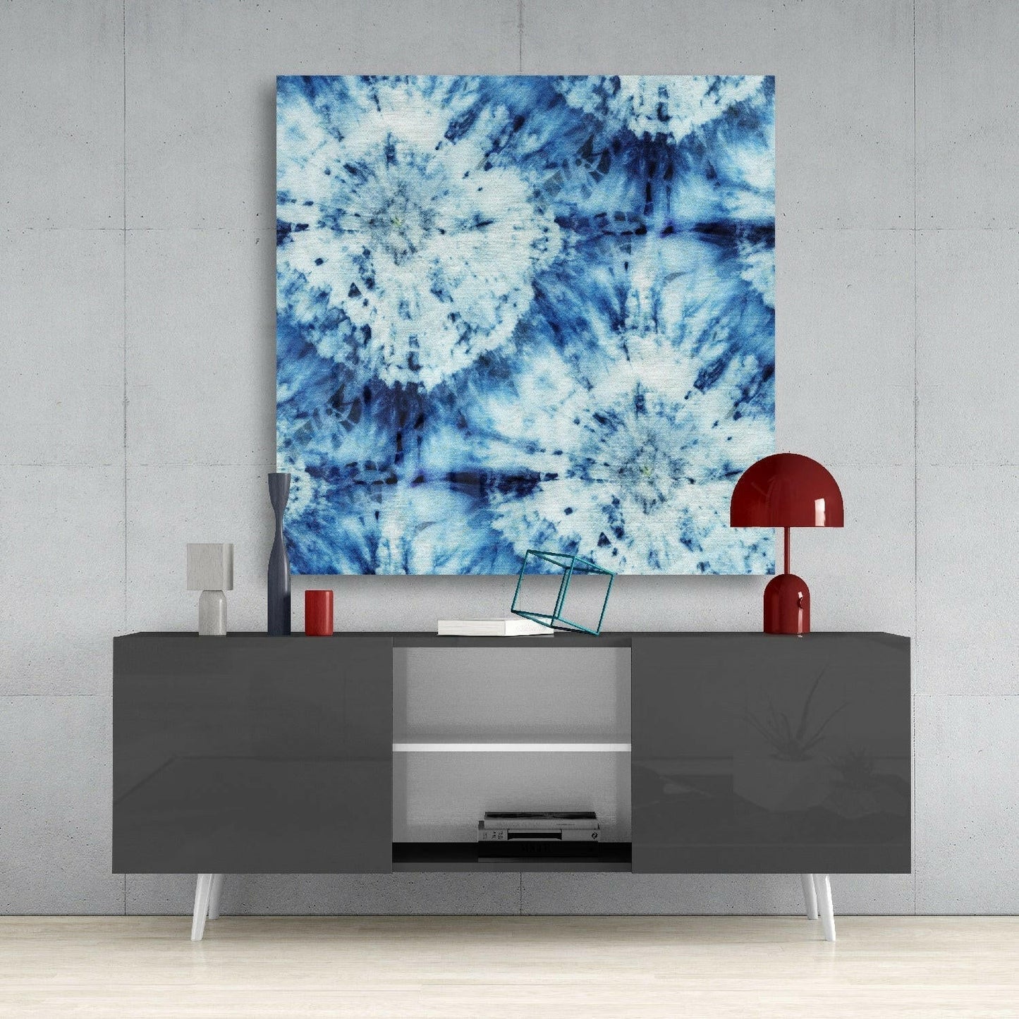 Blue and white tie-dye patterned glass wall art displayed above a dark gray media console with red accents.