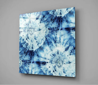 Blue and white glass wall art panel displayed at an angle against gray background, showing abstract tie-dye pattern.