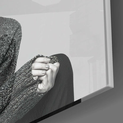 Close-up of hands wearing textured gray sweater and dark pinstriped garment, holding frosted glass art depicting antelope profile.