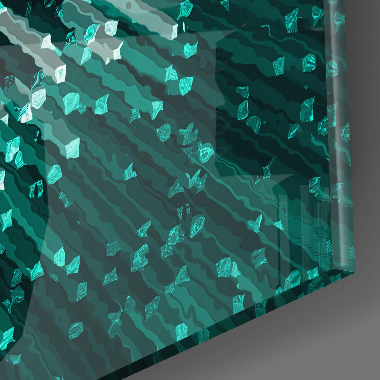 Close-up angled view of layered turquoise and teal glass wall art with leaf-shaped cutouts casting shadows.