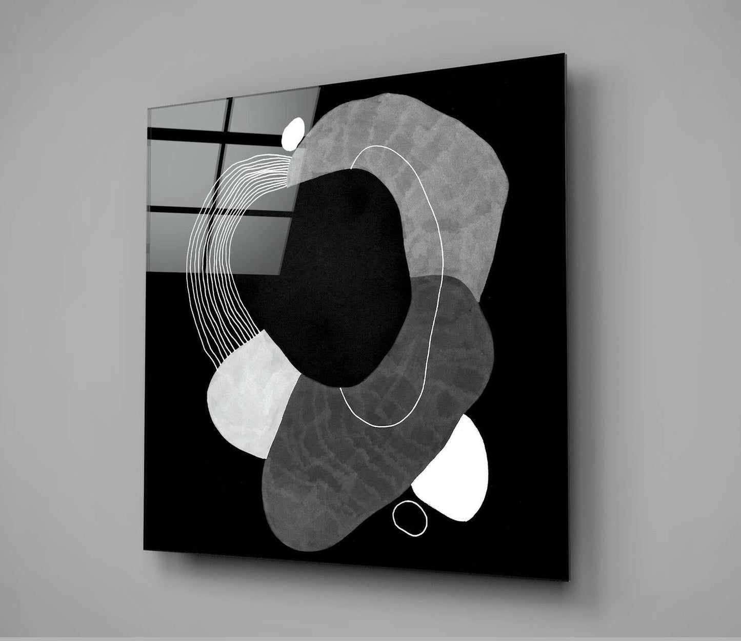 Black glass wall art displaying abstract geometric shapes in grayscale with white line details against dark background.