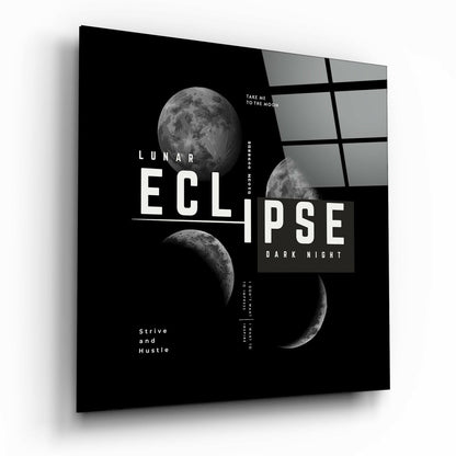 Angled view of black glass wall art featuring lunar eclipse phases, white typography, and gray grid pattern on right side.