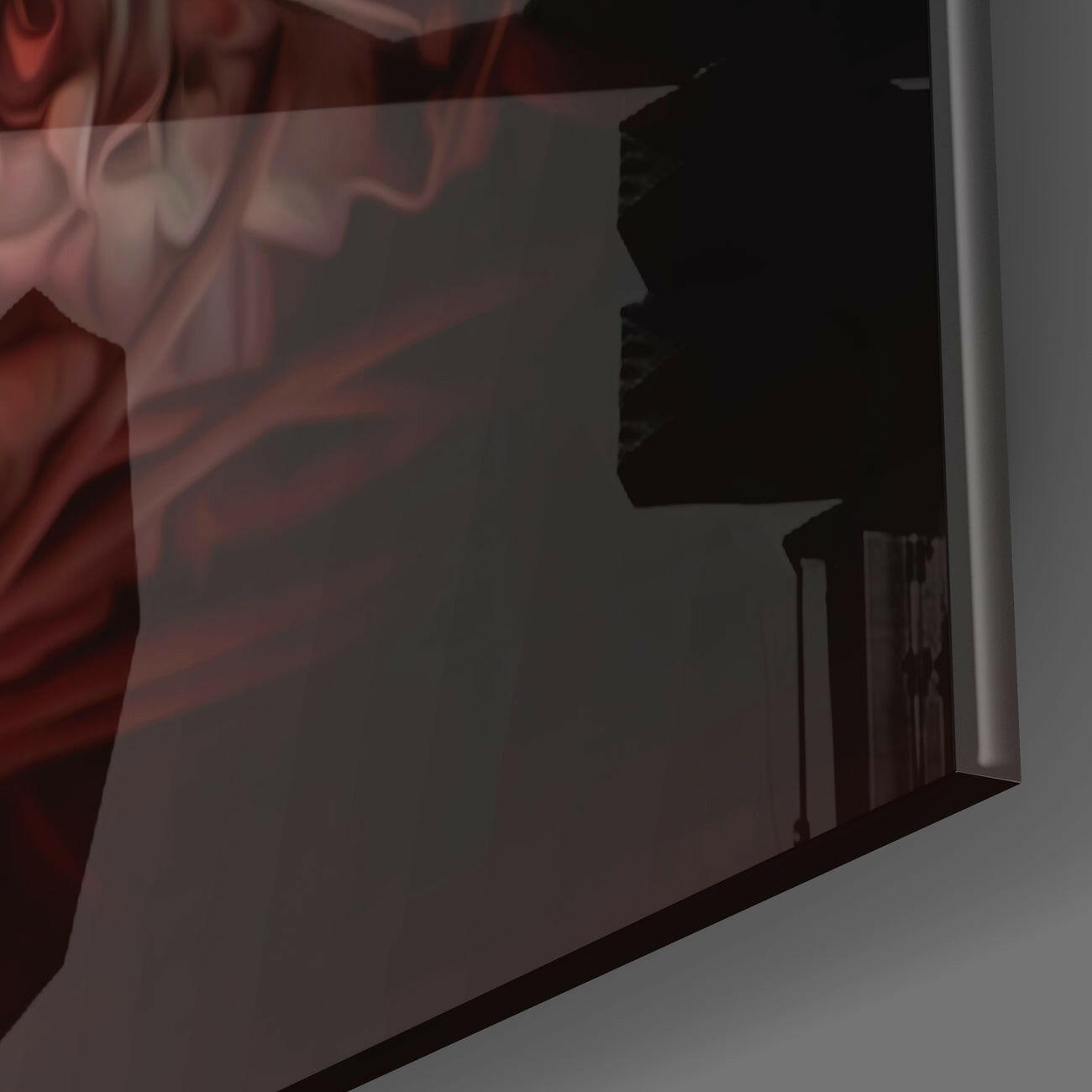 Close-up angled view of frosted glass wall art with black silhouette design and red fabric overlay in upper left corner.
