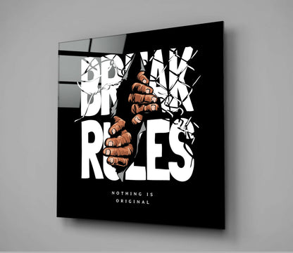 Black glass wall art panel displaying white "BREAK THE RULES" text with brown illustrated fist and branches, angled view showing depth.