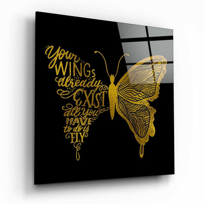 Angled view of black glass wall art featuring gold butterfly and inspirational text about wings and flying.
