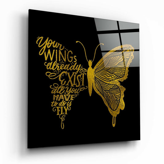 Angled view of black glass wall art featuring gold butterfly and inspirational text about wings and flying.