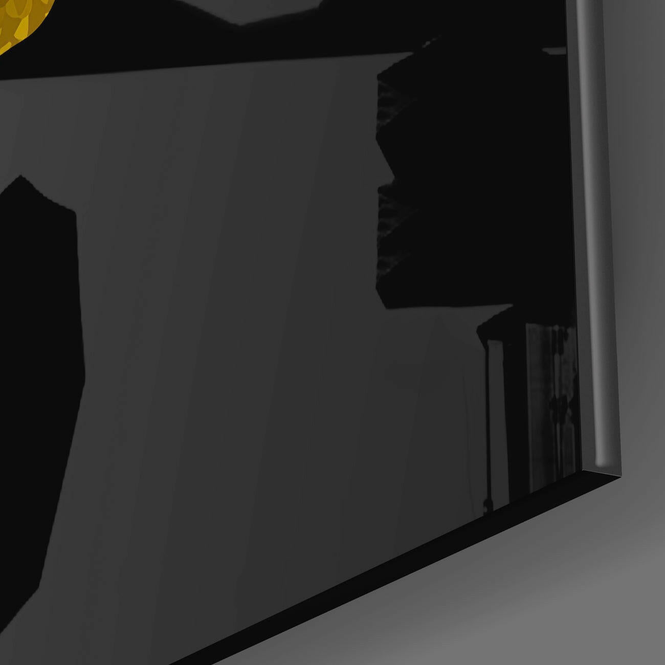 Close-up side view of black glass wall art panel with embossed wing design against gray background.