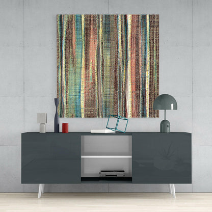 Striped multicolored textile wall art in earthy tones displayed above a dark gray media console in a modern interior setting.