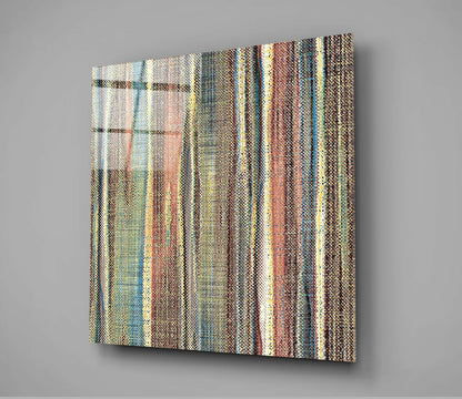 Angled perspective view of textured glass wall art featuring vertical stripes in cream, brown, teal, and yellow tones against gray background.