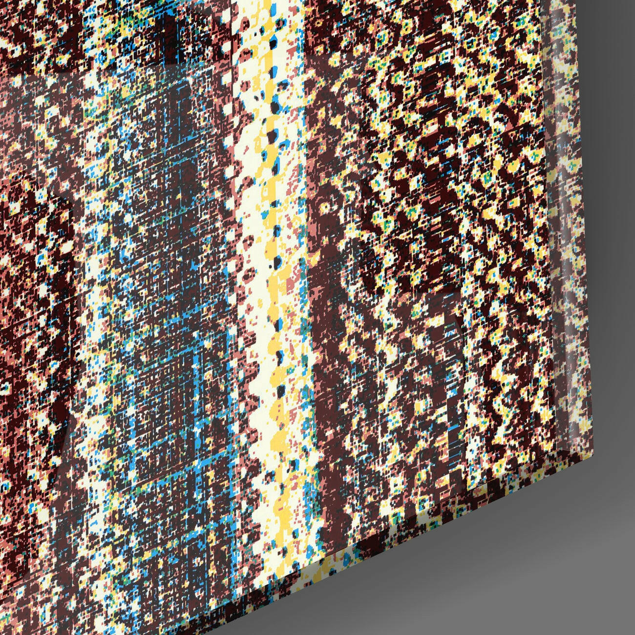 Three-dimensional angled view of textured glass wall art displaying geometric ethnic patterns in burgundy, blue, yellow, and cream colors.